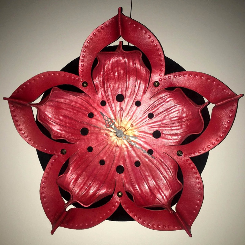 Image of a clock in the form of a dwarf azalea flower. It has five points to the flower and is a rich, deep pink colour.